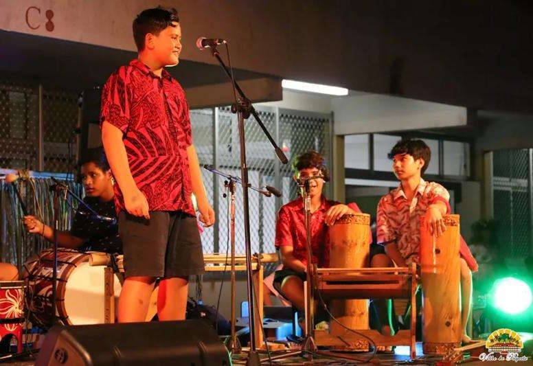 Élève chantant, accompagné de percussionnistes